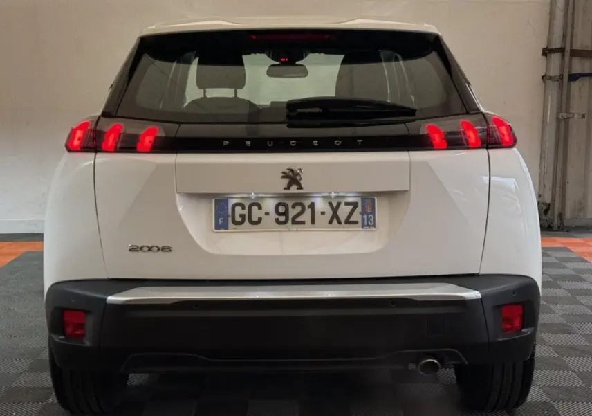 Vue arrière d'un Peugeot 2008 blanc avec feux LED distinctifs et plaque d'immatriculation française visible.