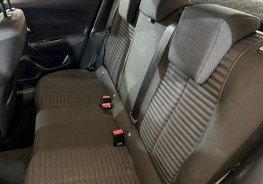 Vue latérale des sièges arrière noirs avec surpiqûres rouges dans le Peugeot 2008 blanc, version Active Business 2021.