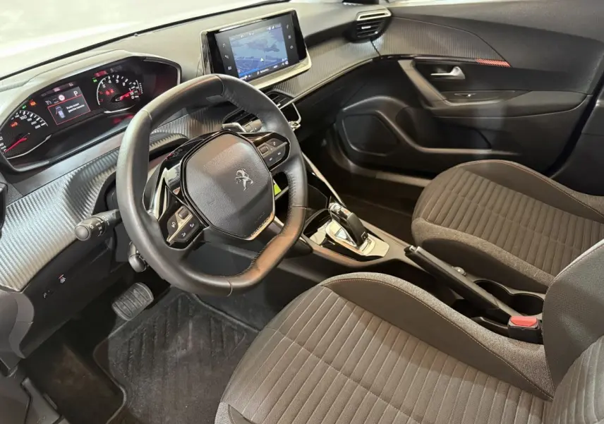 Vue intérieure côté conducteur du Peugeot 2008 2021 avec volant cuir, tableau de bord numérique et écran tactile central.