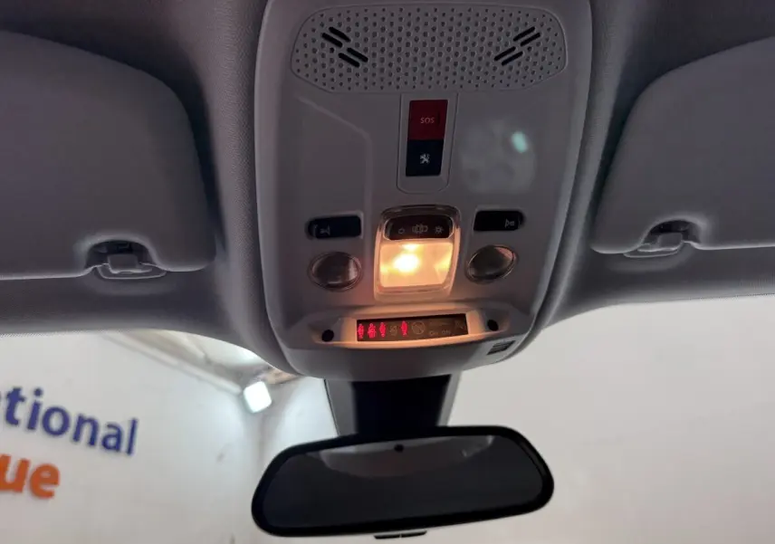 Vue intérieure du plafonnier avec éclairage allumé et miroir intérieur d'une Peugeot 2008 blanche de 2021.