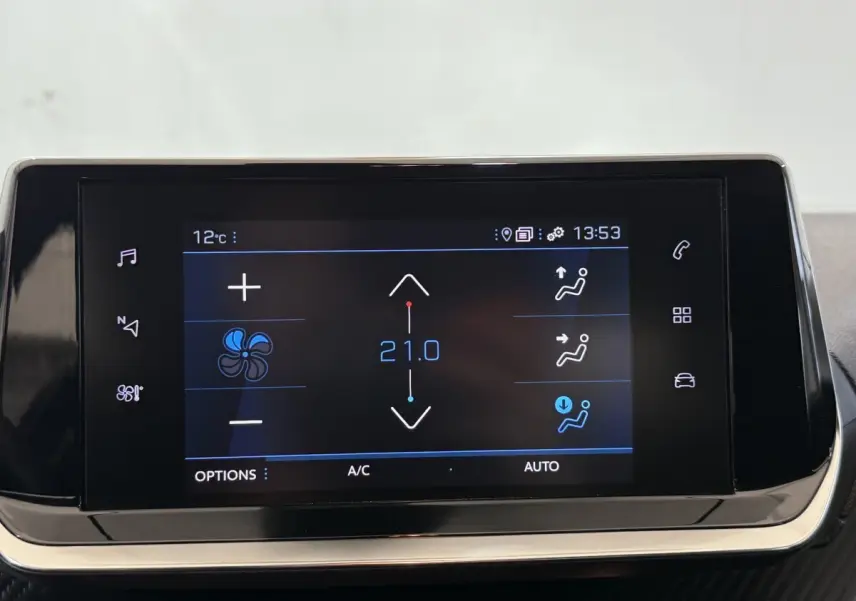 Écran tactile central du tableau de bord du Peugeot 2008 blanc, affichant les réglages de climatisation à 21°C.