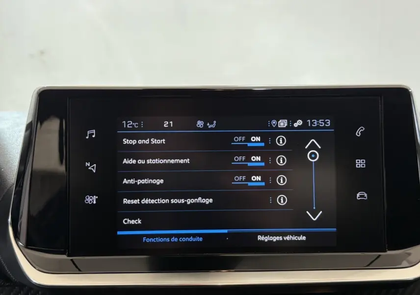 Écran tactile central du tableau de bord du Peugeot 2008 blanc, affichant les réglages d’aides à la conduite.