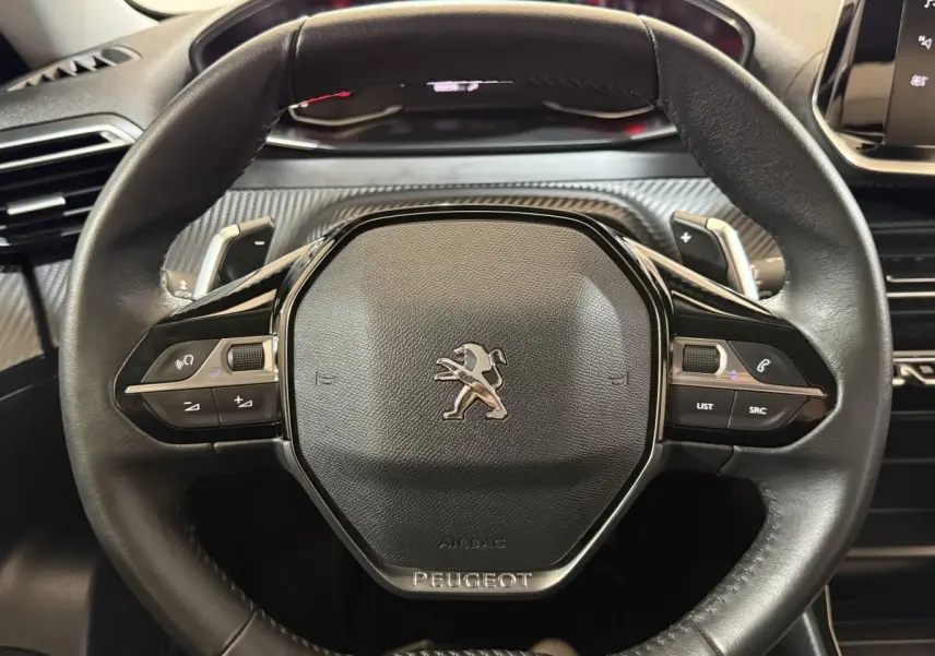 Volant cuir noir Peugeot 2008 vue de face avec commandes intégrées et logo lion central chromé.