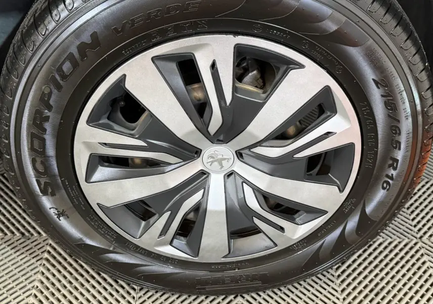 Gros plan sur la jante alliage bicolore et pneu Pirelli Scorpion Verde du Peugeot 2008 blanc de 2021.