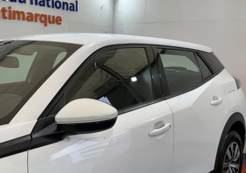 Vue côté gauche rapprochée du Peugeot 2008 blanc, mettant en valeur la porte arrière et le rétroviseur.