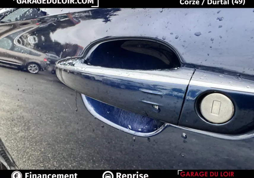 Poignée de porte bleue métallisée du DS7 Crossback 2024 avec serrure intégrée, vue en gros plan côté droit.