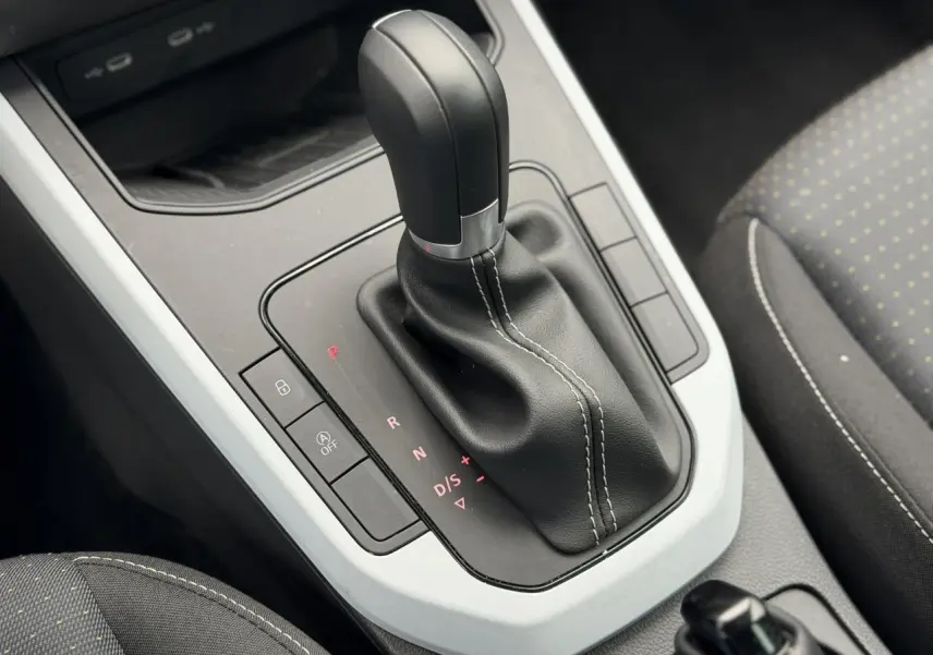 Le levier de vitesse automatique noir avec coutures blanches du SEAT Arona TSI 115 DSG Style, vue intérieure rapprochée.