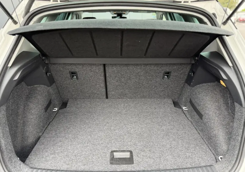 Coffre ouvert en vue arrière d'un SEAT Arona blanc, montrant un espace de rangement propre et bien fini.