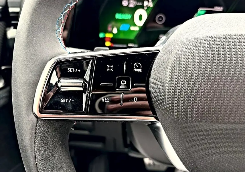 Gros plan sur la partie gauche du volant multifonction du Renault Austral 2026, avec commandes de régulateur et mode de conduite.