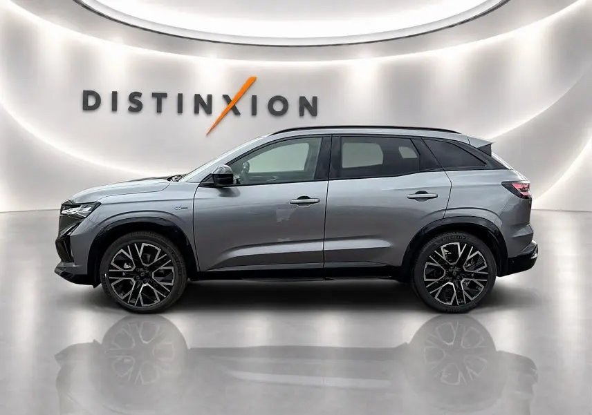 Profil droit du Renault Austral gris schiste 2026 avec jantes alu noires et toit noir dans un showroom lumineux.