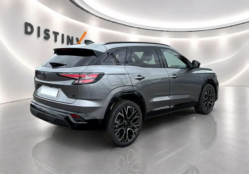 Renault Austral gris schiste en 3/4 arrière droit, avec jantes alu noires et toit noir contrasté dans un studio lumineux.