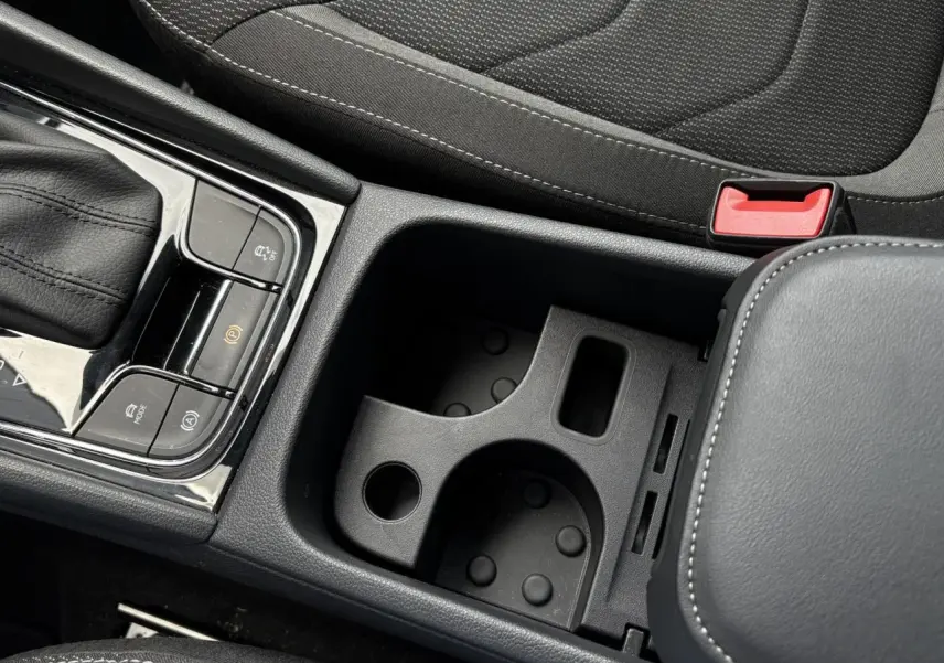 Gros plan sur la console centrale noire du Skoda Kodiaq 2024, montrant le levier de vitesses et les porte-gobelets.