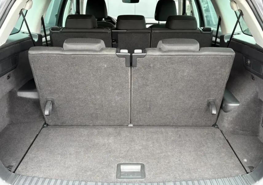 Vue arrière du coffre du Skoda Kodiaq 1.5 TSI gris graphite avec sièges arrière rabattus en position verticale.