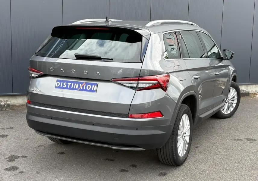 Vue 3/4 arrière droite d'un Skoda Kodiaq gris graphite avec feux arrière LED et jantes alliage 18 pouces.