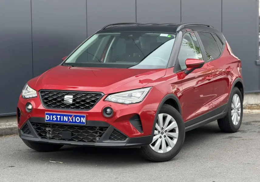 SEAT Arona TSI 115 Style rouge Désir avec toit noir, vue 3/4 avant mettant en valeur la calandre et les phares LED.
