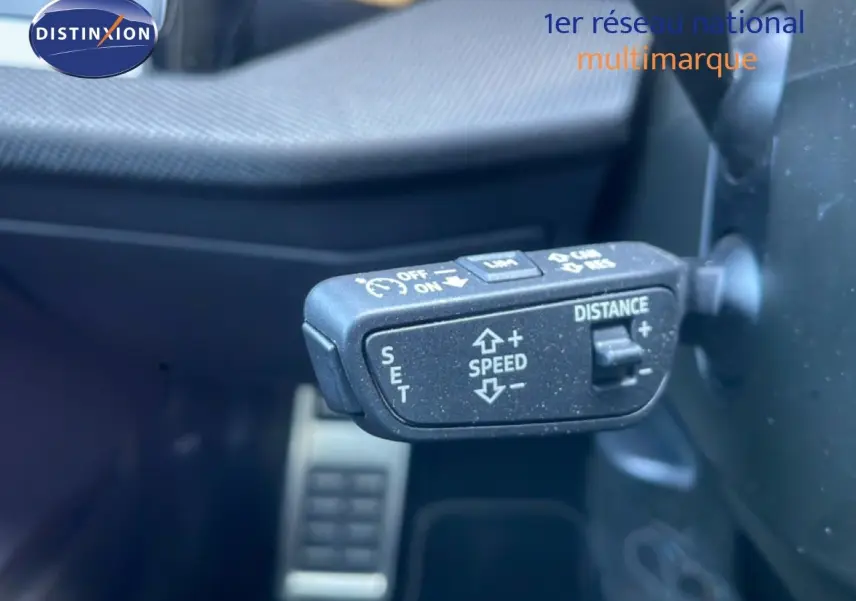 Gros plan sur la commande de régulateur de vitesse adaptatif à gauche du volant dans l’Audi A3 Sportback noir Mito Metal 2025.