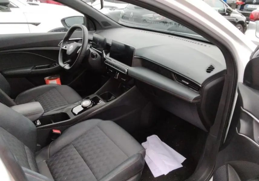 Intérieur de la MG3 1.5 Hybrid+ 195 Luxury vue côté passager, sellerie tissu/similicuir noir et tableau de bord moderne.