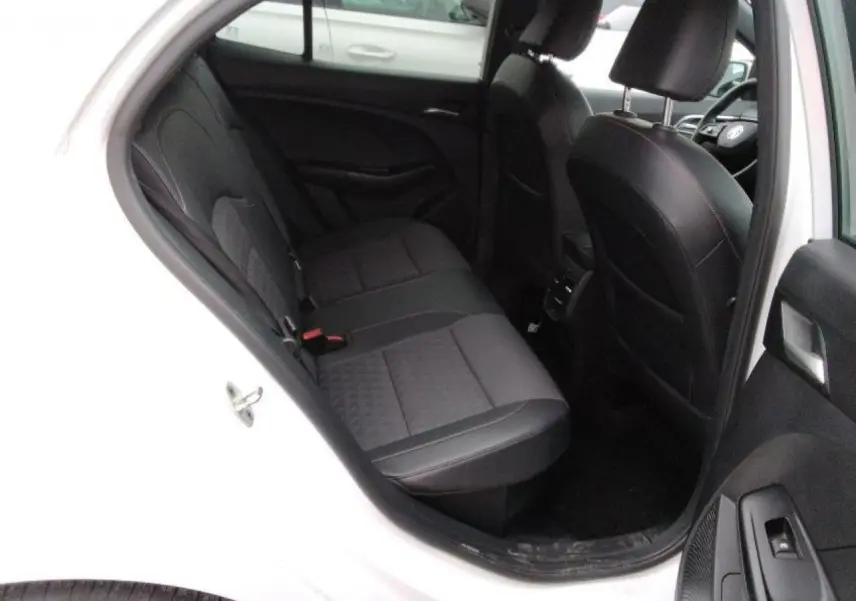 Vue intérieure côté arrière gauche du MG3 blanc Dover, montrant les sièges arrière en tissu et similicuir noir.