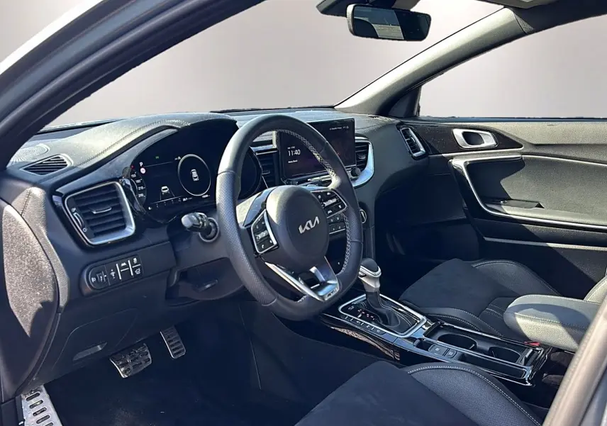Intérieur avant du Kia Xceed gris 2024, vue côté conducteur, volant cuir multifonction et console centrale avec boîte auto.