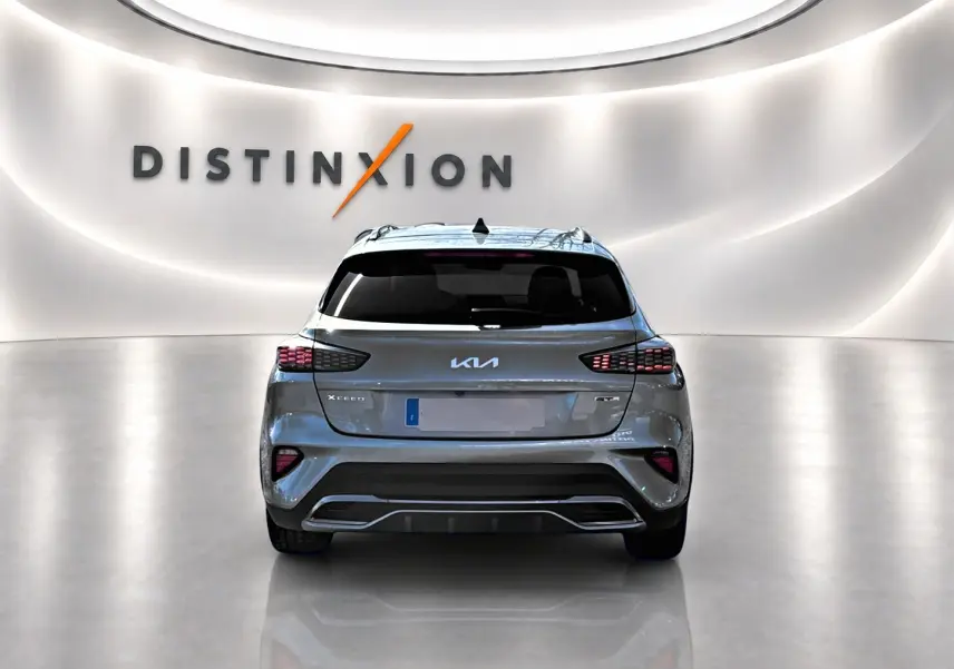 Vue arrière d'une KIA Xceed gris métallisé 2024 avec feux LED et logo distinctif dans un showroom lumineux.