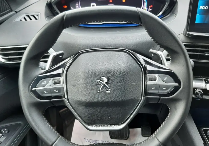 Volant cuir noir avec commandes intégrées du Peugeot 3008 Hybrid 136 vue de face sur tableau de bord digital.