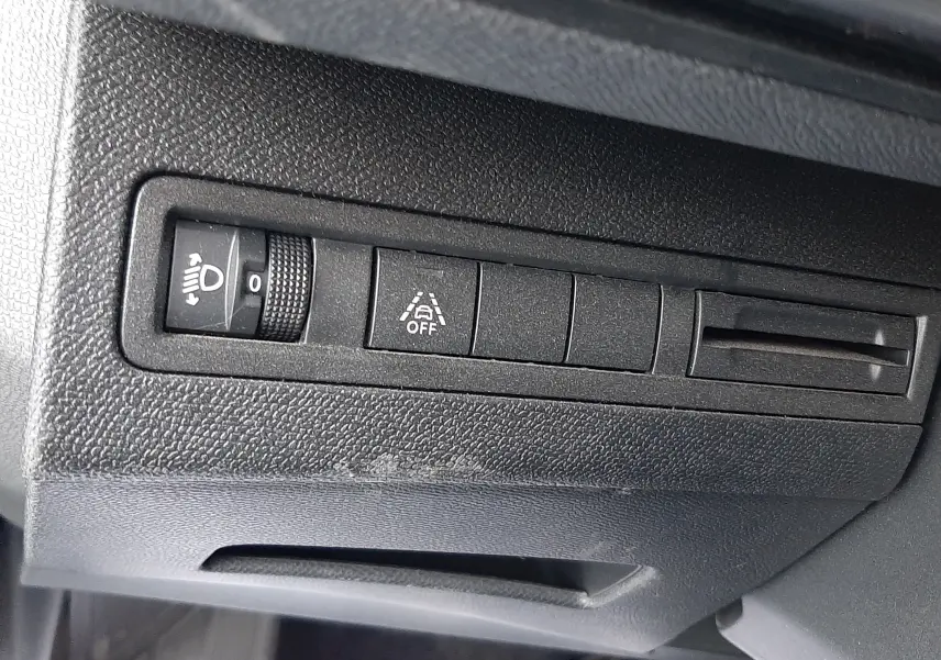 Détail des commandes de réglage d'éclairage et d'aide à la conduite sur le tableau de bord du Peugeot 3008 Hybrid 2024.