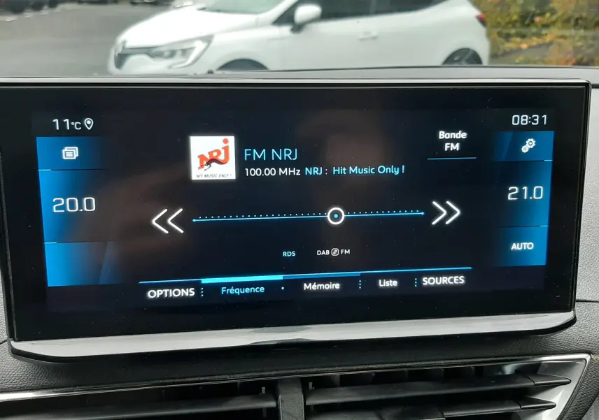 Écran tactile central du Peugeot 3008 Hybrid gris Artense affichant la radio FM NRJ à 08h31, intérieur moderne.