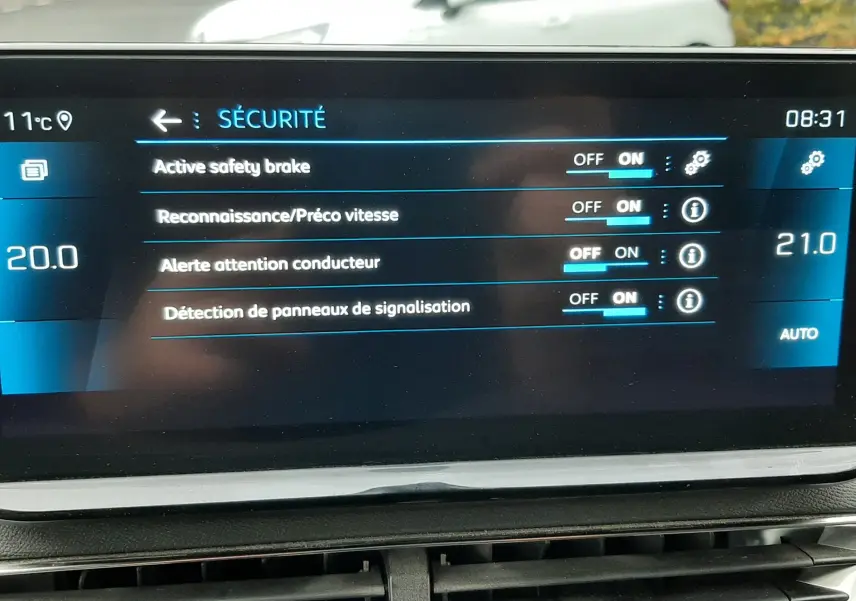Écran tactile du tableau de bord du Peugeot 3008 Hybrid 136 en intérieur, affichant les réglages de sécurité.