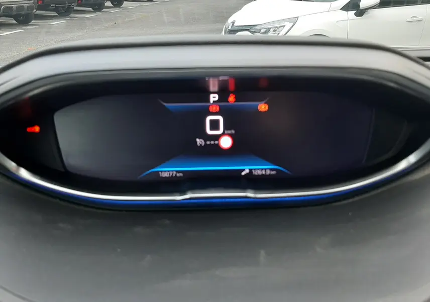 Tableau de bord numérique du Peugeot 3008 Hybrid 136 en vue frontale, affichant la vitesse à zéro et plusieurs alertes.