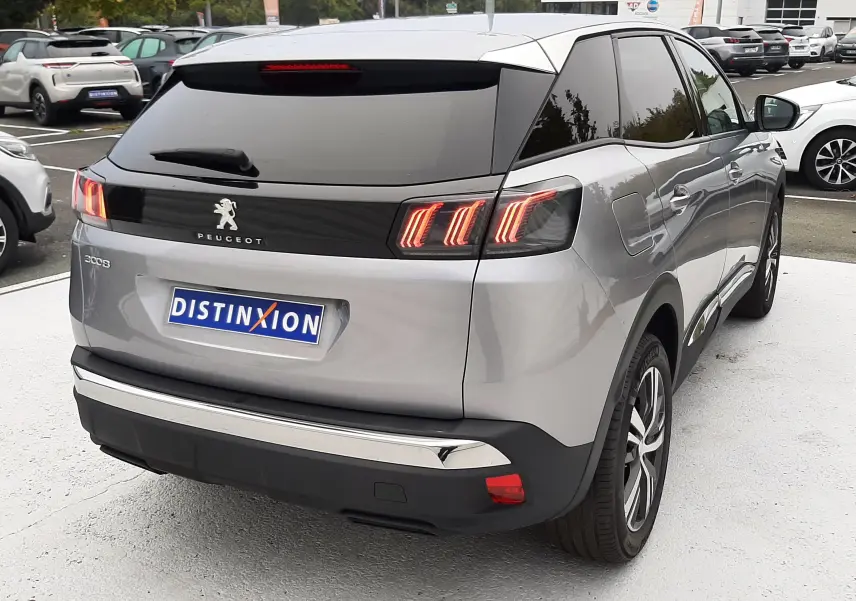 Vue 3/4 arrière droite du Peugeot 3008 Hybrid 136 gris Artense avec feux arrière LED allumés et vitre teintée.
