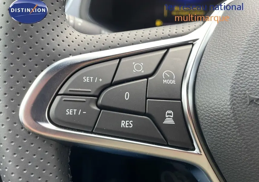 Gros plan sur les commandes de régulateur de vitesse au volant perforé du Renault Captur E-Tech hybride 2025.