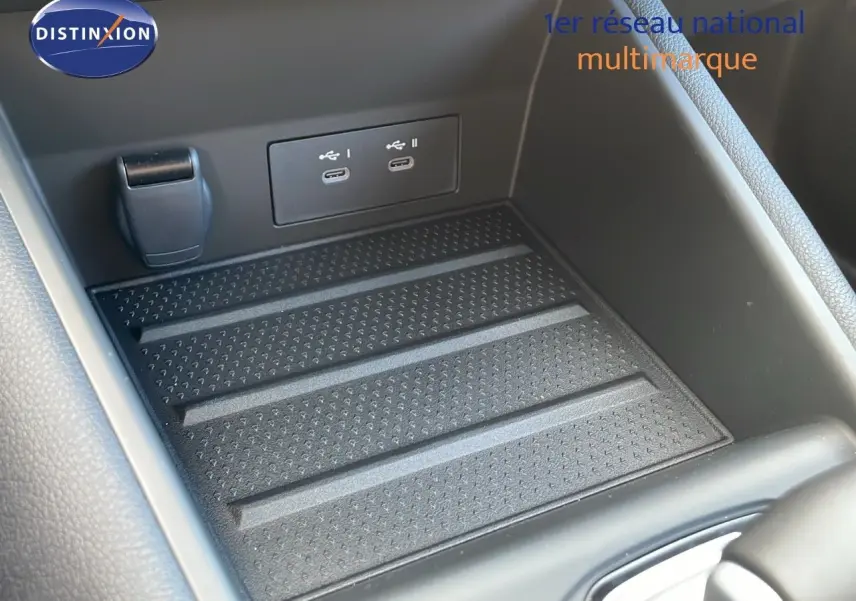 Gros plan sur la console centrale noire du Renault Captur E-Tech hybride, montrant deux ports USB-C et un espace de rangement.