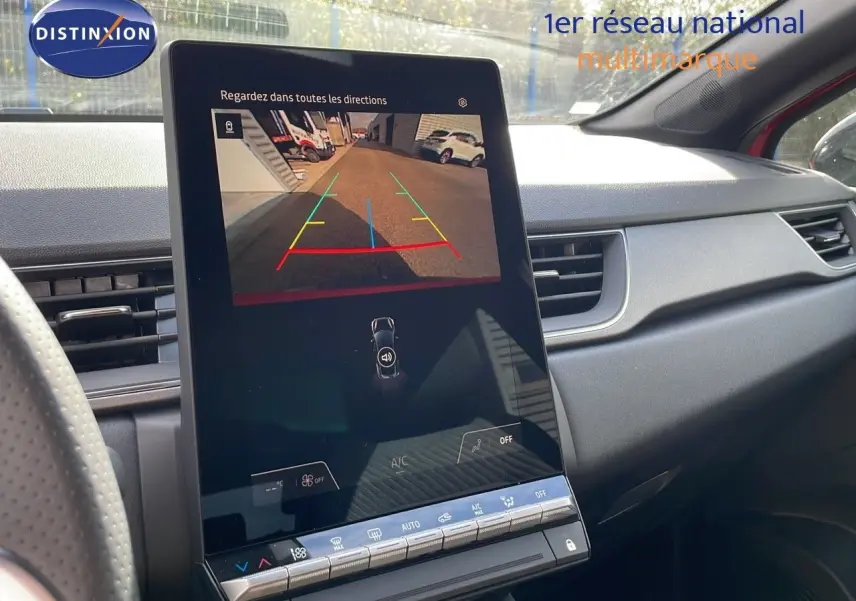 Vue intérieure du tableau de bord du Renault Captur E-Tech rouge, avec écran tactile affichant la caméra de recul.