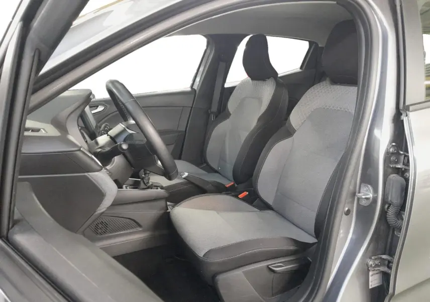 Vue intérieure côté conducteur de la Renault Clio V gris schiste, sièges textile gris à motif 3D et volant textile grainé.