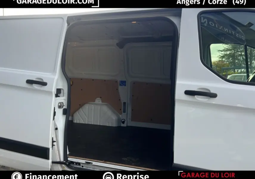 Vue latérale du Ford Transit Custom blanc 2023 avec porte coulissante ouverte montrant l’espace de chargement vide.