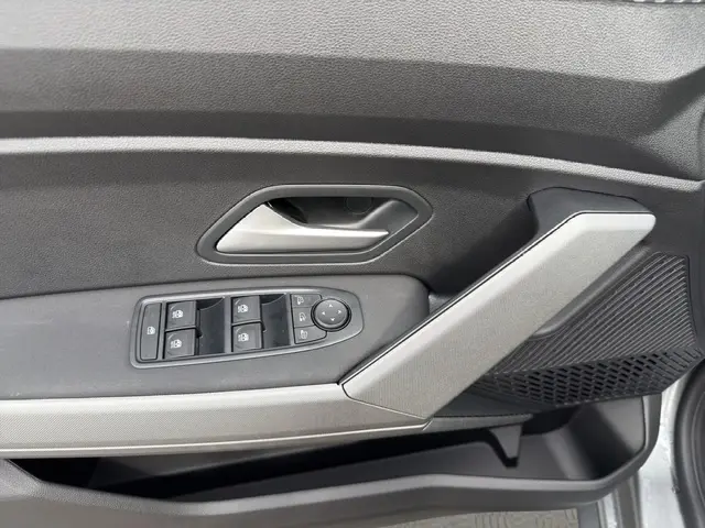 Détail de la porte intérieure côté conducteur du Dacia Bigster gris foncé, avec commandes des vitres et poignée argentée.