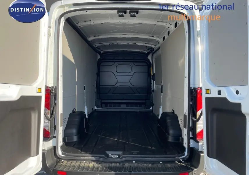 Vue arrière du fourgon blanc Ford Transit 350 L3H2 2023 avec portes ouvertes montrant l'espace de chargement vide.