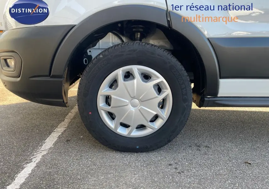 Gros plan sur la roue avant gauche du Ford Transit Fourgon blanc 2023, avec jante en plastique et pneus robustes.