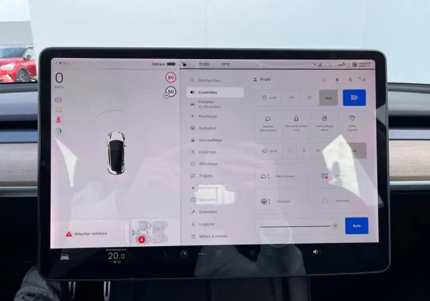Écran tactile central de la Tesla Model 3 blanc 2022, affichant les réglages de conduite et sécurité.