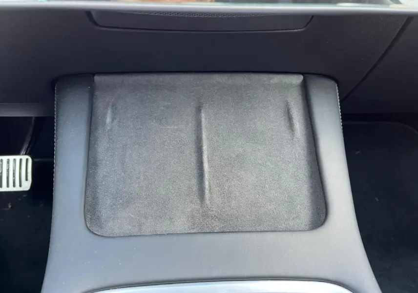 Gros plan sur l'accoudoir central noir de la Tesla Model 3 Standard Plus RWD 2022, intérieur premium partiel.