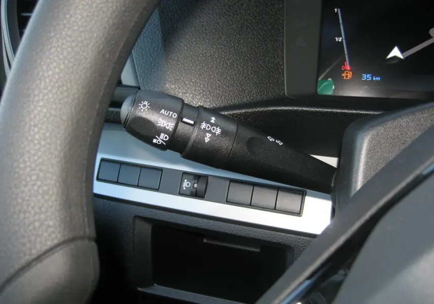 Gros plan sur la manette des feux et clignotants à gauche du volant dans l'habitacle du Peugeot Expert Fourgon blanc.