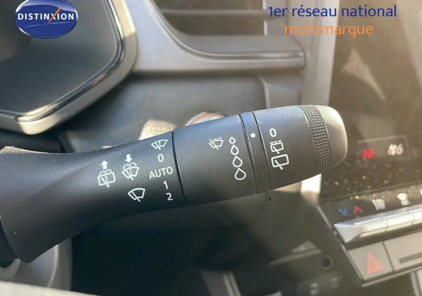 Gros plan sur la manette d'essuie-glace du tableau de bord du Renault Captur gris Rafale métal avec toit noir.