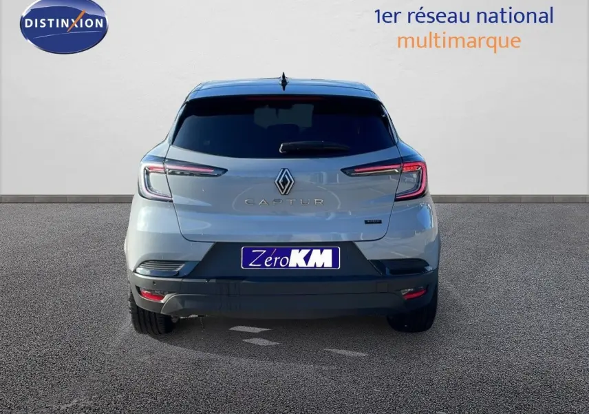Vue arrière du Renault Captur E-Tech hybride gris Rafale avec toit noir et feux LED allumés sur fond neutre.