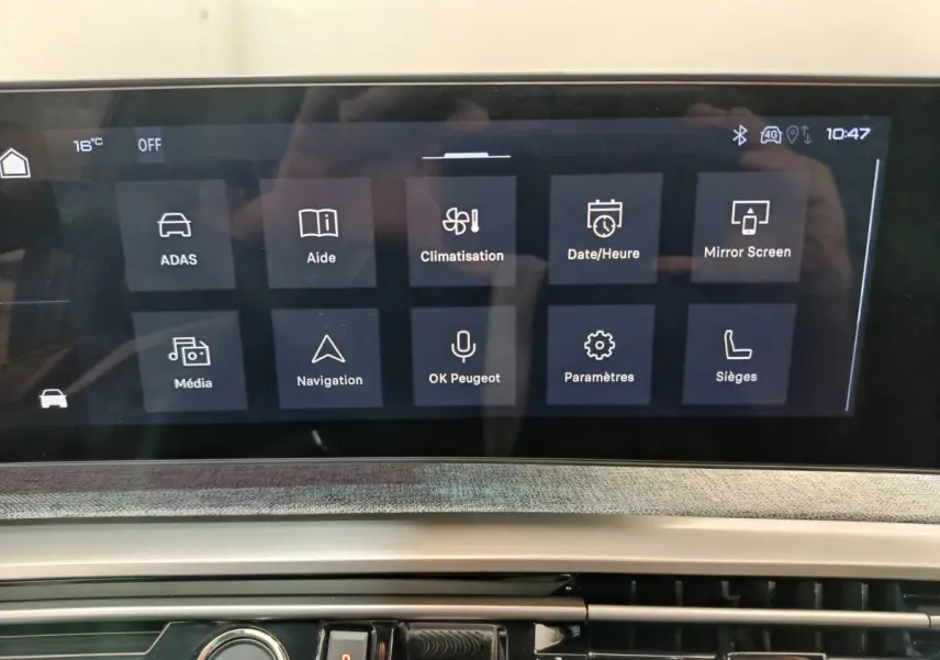 Écran tactile central affichant les menus de navigation et climatisation dans un Peugeot 3008 gris clair 2025.