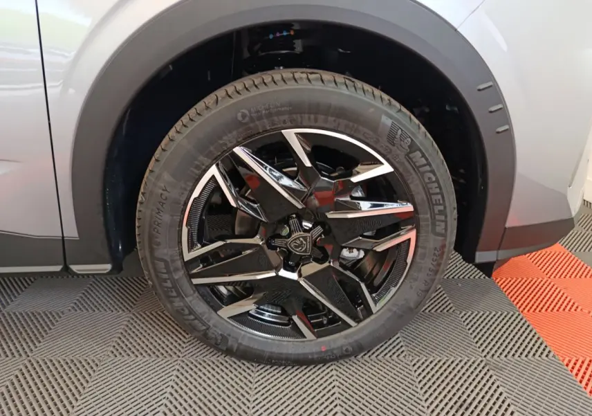 Gros plan sur la roue avant gauche du Peugeot 3008 gris clair avec jante alliage noire et chromée.