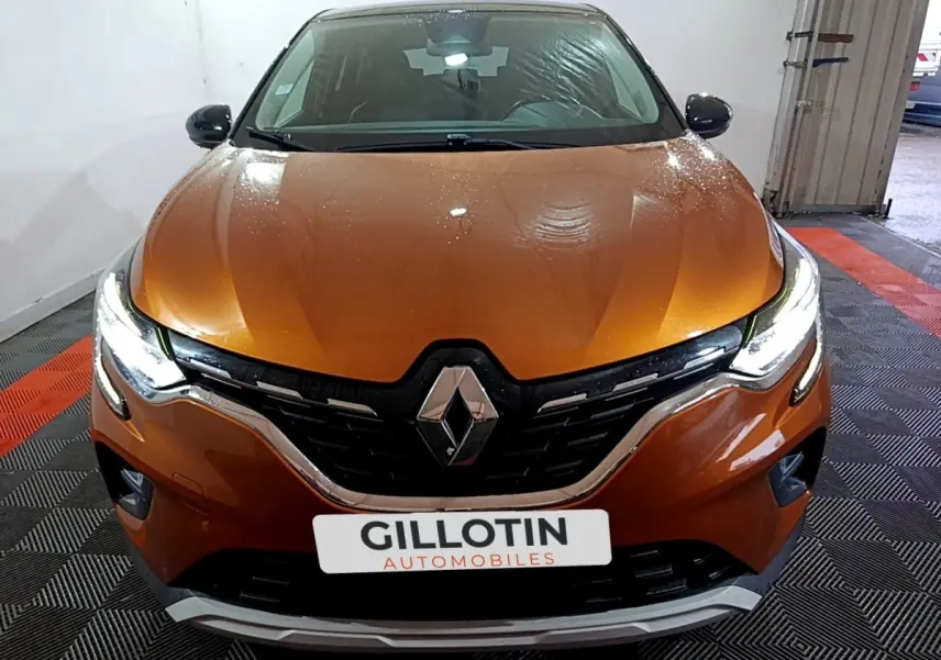 Vue avant rapprochée du Renault Captur jaune avec phares LED allumés dans un garage.