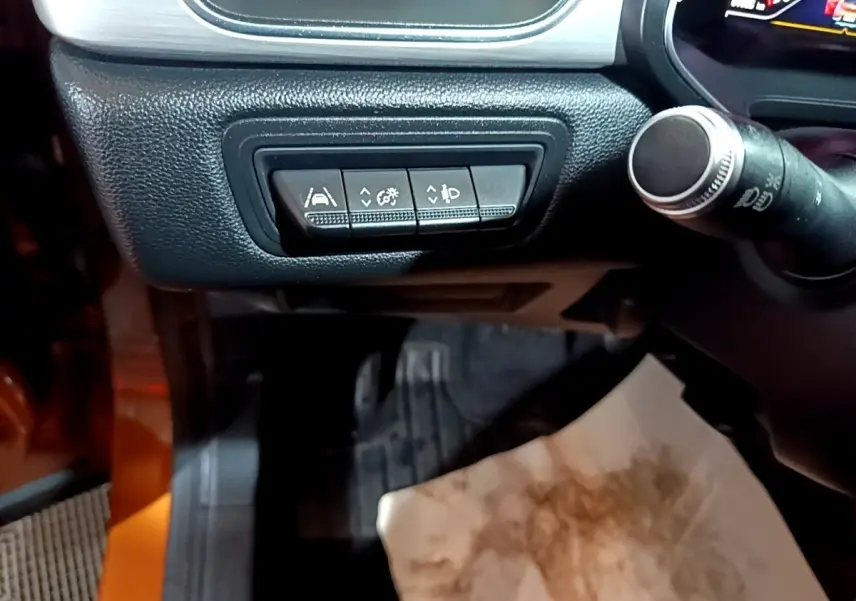 Gros plan sur les commandes d'assistance au conducteur côté gauche du tableau de bord du Renault Captur jaune 2020.