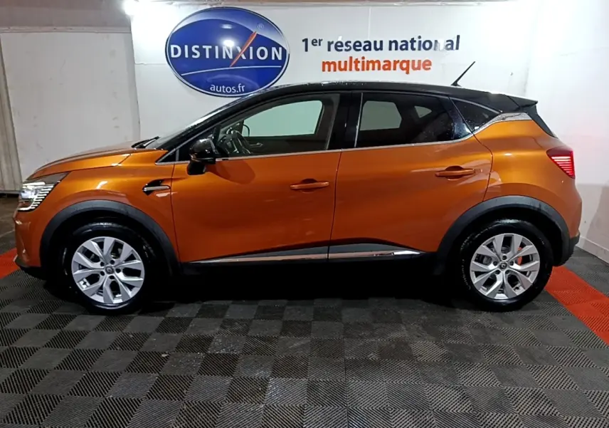 Profil droit d'un Renault Captur Intens 2020 orange métallisé avec toit noir, jantes alliage et rétroviseurs noirs.