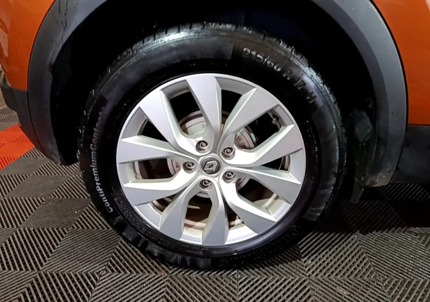 Gros plan sur la roue avant gauche du Renault Captur jaune, mettant en valeur la jante alliage argentée au design moderne.