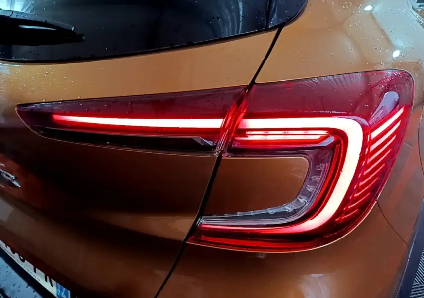 Feu arrière droit allumé d’un Renault Captur jaune 2020, vue rapprochée sous la pluie.